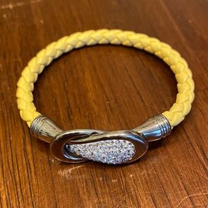 Yellow leather braided bracelet with rhinestone clasp.
